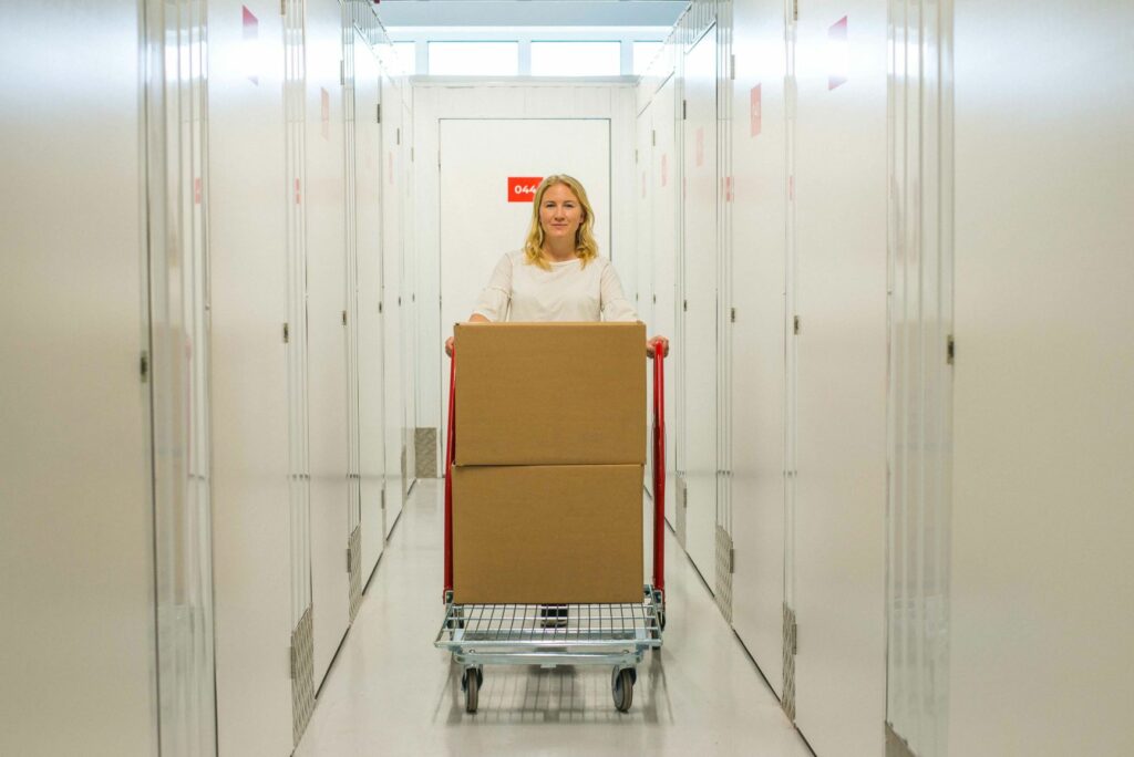 One lady pushing two boxes on a trolley in a flexistore facility.