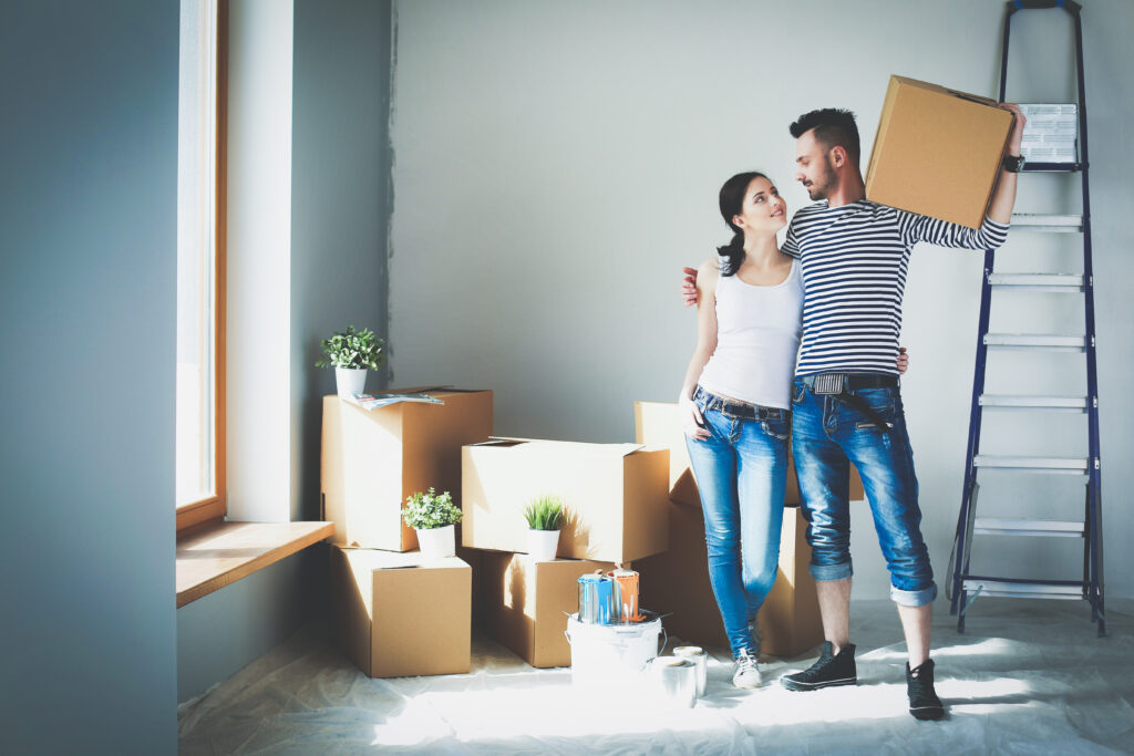 Happy young couple unpacking or packing boxes and moving into a new home.