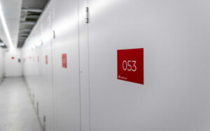 Hallway of secure self-storage units at flexistore in stellenbosch, featuring clean, white doors labeled with red unit numbers for easy identification. Ideal for organized and reliable storage solutions.